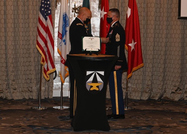 U.S. Army Maj. Gen. Ross Coffman, director of the Next Generation Combat Vehicle Cross-Functional Team, pins the Distinguished Service Medal to Command Sgt. Maj. Paul Biggs during his retirement ceremony at Joint Base Langley-Eustis, Virginia, May 13, 2021. Biggs retired after serving more than 33 years in various levels of leadership to include his last position as the Futures and Concepts Center command sergeant major. (U.S. Army photo by David Miller)