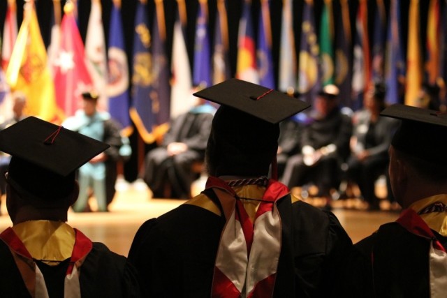 Soldiers and civilians stand as their degrees are conferred by their colleges&#39; representatives during a Fort Knox Army Education Center college graduation ceremony at Waybur Theater, Oct. 17, 2019, on Fort Knox, Ky.