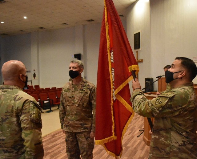 Sergeant First Class Joseph Harrison prepares to pass on the colors of the Afghanistan District to the Commanding Officer, Colonel Mark Geraldi and Senior Enlisted Advisor, Sergeant Major Ronald Brown to ready it to be cased.