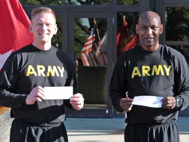 Maj. Gen. Darren Werner (left), Commanding General U.S. Army Tank-automotive and Armaments Command, and Command Sgt. Maj. Jerry Charles (right), TACOM, display their signed donation forms for the Army Emergency Relief campaign during a run/walk...
