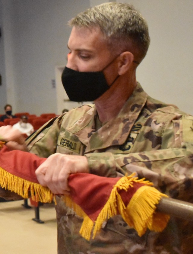 Colonel Mark Geraldi, Afghanistan District puts the final touches on the colors of the District as they are cased for the final time during a ceremony at Camp Arifjan, Kuwait on May 15, 2021.