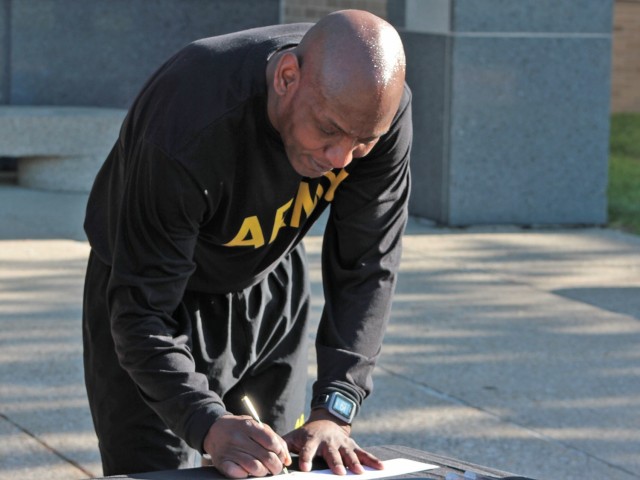 Command Sgt. Maj. Jerry Charles, U.S. Army Tank-automotive and Armaments Command, signs his Army Emergency Relief donation during a Run/Walk event for AER at the Detroit Arsenal, Michigan May. 14.