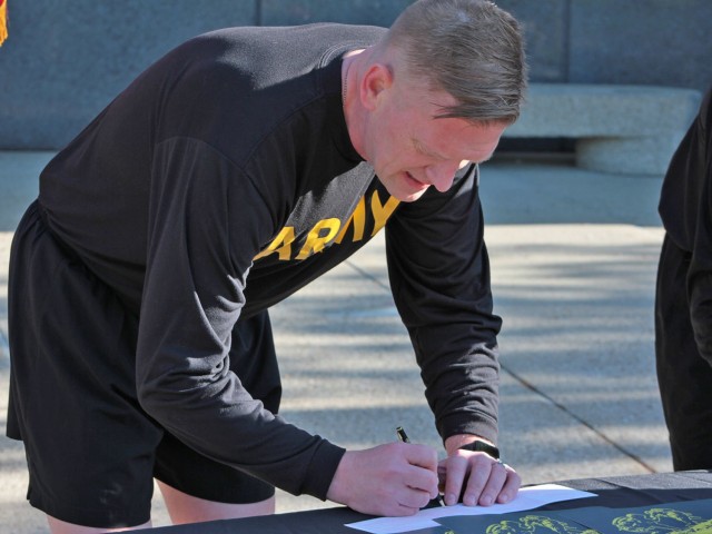 Maj. Gen. Darren Werner, Commanding General U.S. Army Tank-automotive and Armaments Command, signs an Army Emergency Relief donations form at the Detroit Arsenal, Michigan for the AER Run/Walk event May 14.