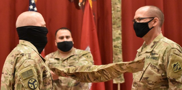 Colonel John Haas, Jr., Outgoing Commander of Task Force Essayons along with Sergeant Major William Klaers, Outgoing Senior Enlisted Advisor stand on either side of the colors of the command which are encased for the final time as Sergeant First...