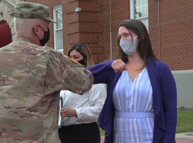 Mrs. Emily Shamsi, a member of the 1st Theater Sustainment Command Soldier and Family Readiness Support Group, gives a friendly elbow to Maj. Gen. John Sullivan, commanding general, 1st TSC, after receiving a Certificate of Appreciation at Fort...