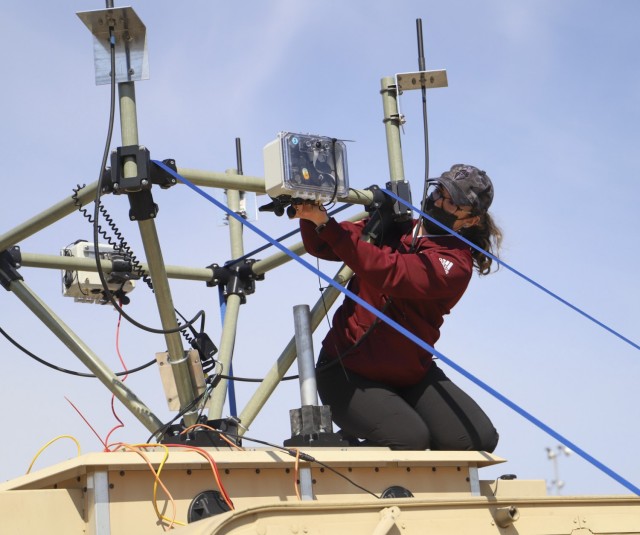 C5ISR Center transportation specialist Sara Miller adjusts a radio component during the Platoon Attack Experiment, April 14, 2021, on Joint Base McGuire-Dix-Lakehurst, N.J. During the experiment, C5ISR Center engineers mounted radios onto multiple on-the-move vehicles to assess robustness and capacity in urban, open and wooded terrain, and resiliency during simulated electronic warfare attacks. 