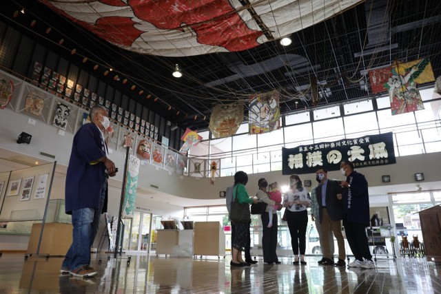 USAG Japan Commander Col. Thomas R. Matelski, USAG Japan Command Sgt. Major Justin Turner and their families view a giant kite hung from the ceiling at the Sagami Giant Kites Center during a visit there near Camp Zama May 12.