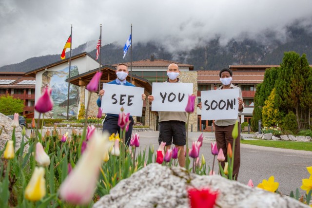 Edelweiss Lodge and Resort is scheduled to reopen on Friday, May 21. Outside the hotel, employees hold up signs that welcome back guests. (U.S. Army Photo)