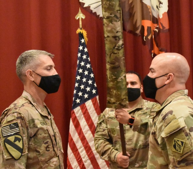 Colonel Mark Geraldi and Master Sergeant Ronald Brown prepare to receive the colors of the new USACE District during the uncasing ceremony held at Camp Arifjan, Kuwait on May 15, 2021.