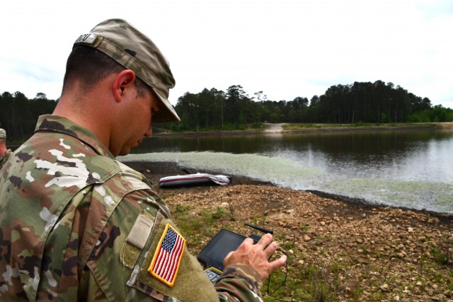 Staff Sgt. Reed Vascocu, 46th Engineer Battalion, works on the controller computing data gathered from the sonar mike.