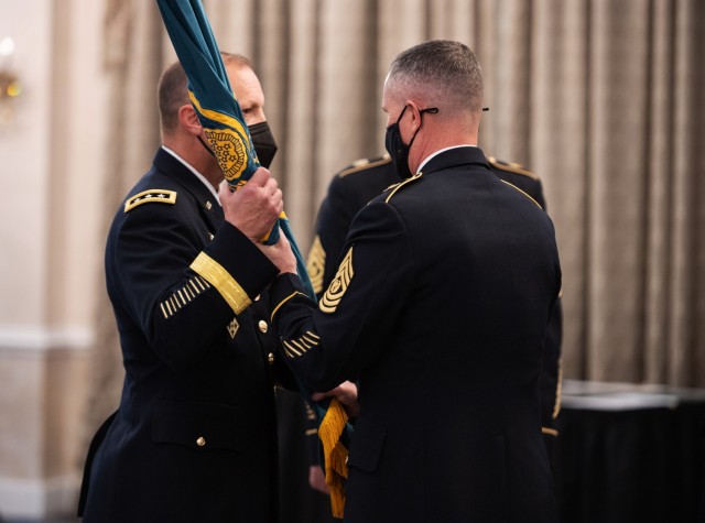 Lt. Gen. D. Scott McKean, Deputy Commanding General, Army Futures Command and Director, Futures and Concepts Center, receives the FCC flag from outgoing Command Sgt. Maj. Paul Biggs during the transfer of responsibility ceremony between outgoing Command Sgt. Maj. Paul Biggs and incoming Command Sgt. Maj. Robin Bolmer at Joint Base Langley-Eustis, Virginia, May 13, 2021. The unit’s flag is used to represent the transfer of responsibility and identify the new command sergeant major to each Soldier now under his charge and signify his commitment, dedication and the loyalty to the FCC team. 