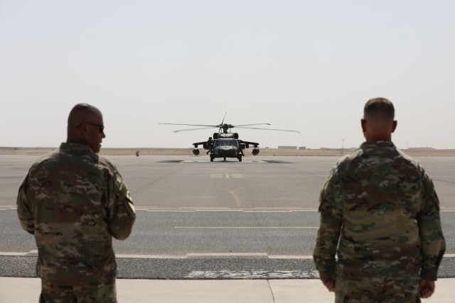 Task Force Phoenix Command Sgt. Maj. Refugio Rosas and commander Col. Alan Gronewold await the arrival of a party of visitors from Combined Joint Task Force - Operation Inherent Resolve on the flight line at Camp Buehring, Kuwait, before a...