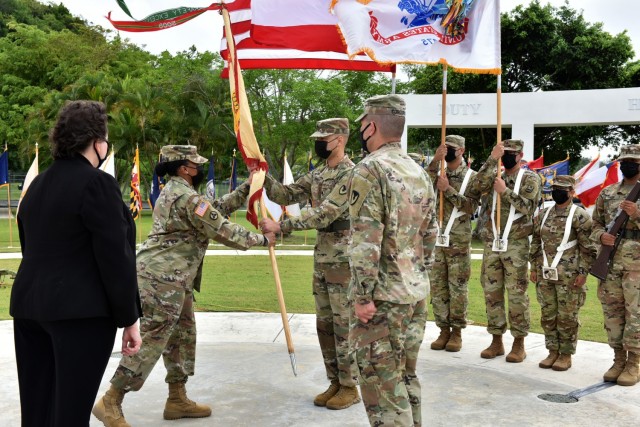 Col. Tomika M. Seaberry, in her first official act as Fort Buchanan Garrison Commander, passing the Garrison Colors to Garrison Command Sgt. Maj. José A. Banks.
