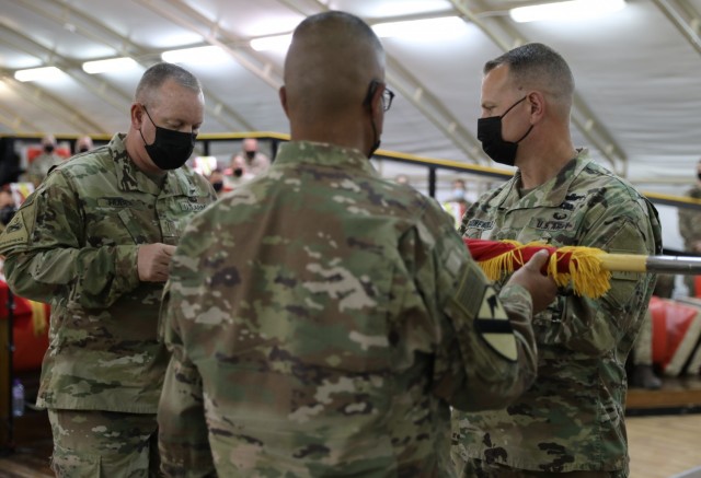 From left, Command Chief Warrant Officer 5 Rich Huber, Command Sgt. Maj. Refugio Rosas and Commander Col. Alan Gronewold uncase the 40th Combat Aviation Brigade&#39;s colors during a Transfer of Authority ceremony at Camp Buehring, Kuwait. The uncasing of the colors marks the official beginning of the mission for Task Force Phoenix in the Middle East.