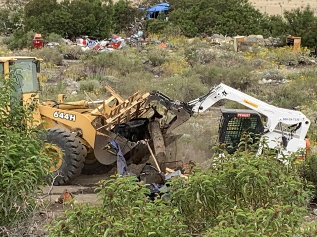 A small tracked skid steer pushes a load of debris to a loader, May 10, 2021, below the Santa Fe Dam in Irwindale, California. The cleanup by the U.S. Army Corps of Engineers Los Angeles District was done in five days.