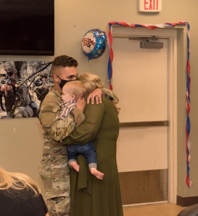 Spc. Deen Alcaraz is welcomed home by his wife and young son.