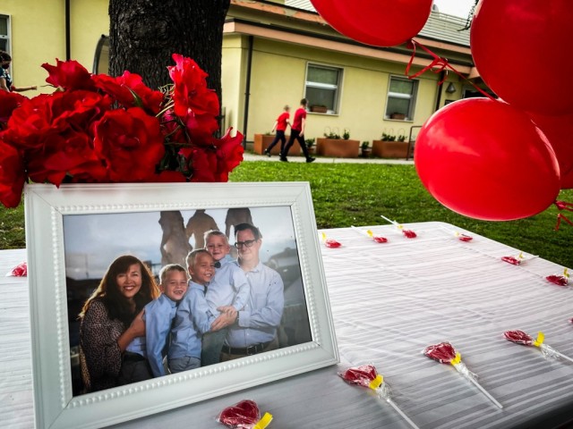 Ehler-Soldatenko family portrait, red flowers and red lollipops for guests decorate the table behind the Thomas Ehler memorial bench in a commemoration ceremony May 17, 2021 at USAG Italy Army Community Service, Vicenza, Italy.