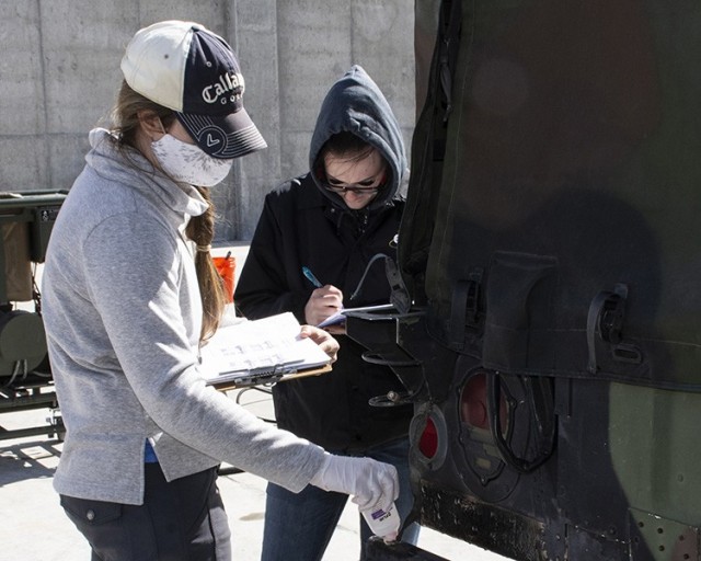 Test personnel apply a simulated chemical agent to a small spot on a vehicle April 20, 2021, so Soldiers may use the Contamination Indicator Decontamination Assurance System spray to reveal it later.