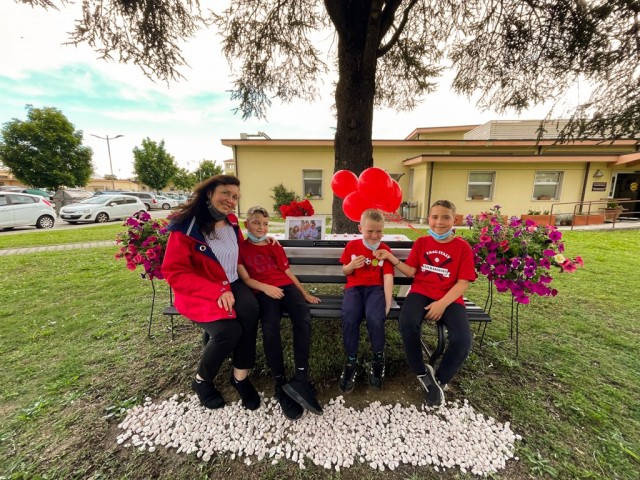 Brian, Matthew and Thomas, Jr. Ehler and widow Tatiana Soldatenko, sit on the memorial bench for Thomas Ehler, in a bench commemoration ceremony May 17, 2021 at USAG Italy Army Community Service, Vicenza, Italy.