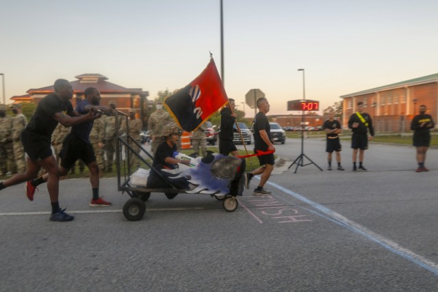 Dogface Soldiers of 703rd Brigade Support Battalion, 2nd Armored Brigade Combat Team, 3rd Infantry Division push their decorated bed across the finish line during the bed race at Fort Stewart, Georgia, May 17, 2021. The bed race kicks off this...