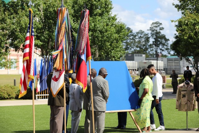 Kasinal Cashe White, sister to Sgt. 1st Class Alwyn C. Cashe, and family begin to uncover a dedication plaque for Sgt. 1st Class Alwyn C. Cashe at the Cashe Garden dedication as part of Marne Week 2021 on Fort Stewart, Georgia, May 20. During...