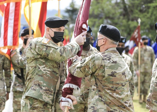 LANDSTUHL, Germany -- (From left) U.S. Army Col. Andrew L. Landers receives the Landstuhl Regional Medical Center unit colors from U.S. Army Brig. Gen. Mark W. Thompson, commanding general, Regional Health Command Europe, during a change of command ceremony where U.S. Army Col. Michael A. Weber relinquished command of LRMC to Landers at LRMC, May 20. Landstuhl Regional Medical Center is the largest American military medical center outside of the United States and plays a strategic role as the sole evacuation and tertiary referral center for five combatant commands.