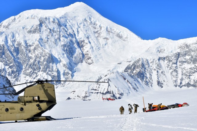 Soldiers from B Company, 1st Battalion, 52nd Aviation Regiment unload equipment and supplies from a CH-47F Chinook helicopter on Kahiltna Glacier, April 22, 2021. Aviators from the unit, also known as the Sugar Bears, traveled from Fort Wainwright to help the National Park Service get the necessary equipment and supplies in place for the base camp at the 7,200-foot level of Kahiltna Glacier for the 2021 climbing season on Denali, the tallest mountain in North America. The mountain in the background is 17,400-foot Mount Foraker. (Army photo/John Pennell)