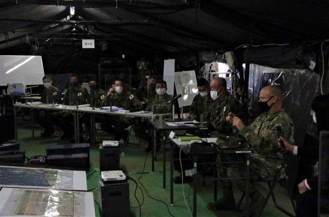 Col. Thomas J. Verell, Jr., Japan Engineer District commander, role plays the part of “Sector 2 Commander” as he takes part in a briefing as part of a Japan Ground Self Defense Force training exercise May 15. The exercise involved building a...