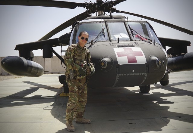 Staff Sgt. Brianna Pritchard, an Army National Guard UH-60 Black Hawk helicopter mechanic from Anchorage, Alaska, poses for a photo in front of a Task Force Phoenix UH-60 Black Hawk MEDEVAC helicopter as Al Asad Air Base, Iraq.                  