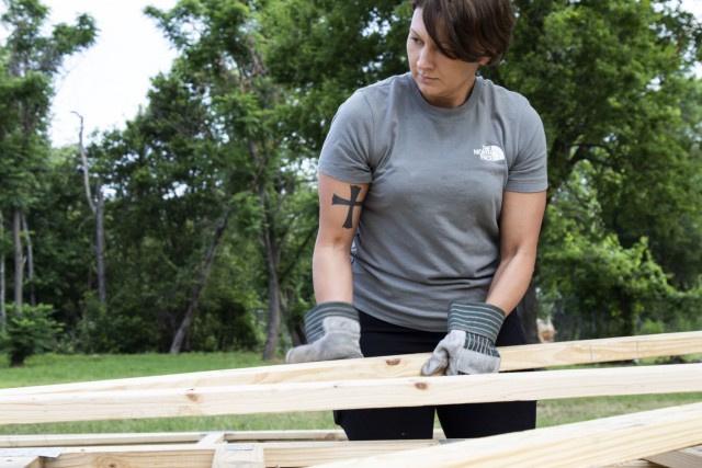 U.S. Army Reserve Sgt. 1st Class Crystal Rowland, a mobilization data reports noncommissioned officer assigned to the Mobilization Demobilization Operations Center (MDOC) from the 2-381st Training Support Battalion, 120th Infantry Brigade, Division West, carries a piece of wood framing while volunteering for a Habitat for Humanity housing project in Waco, Texas, May 16, 2021.  Rowland, who has ties to the Waco community, was instrumental to organizing this volunteering effort for her team. (U.S. Army Photo by Staff Sgt. Erick Yates)