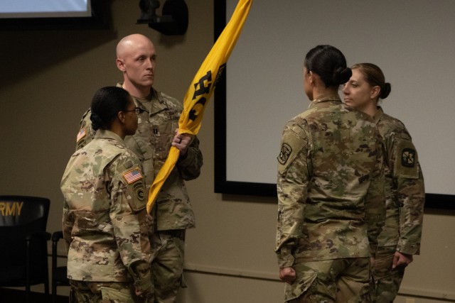 Capt. Adrian Bradley is given the Headquarters & Headquarters Detachment (HHD) colors signaling the first time he will do so as the new Commander of the HHD at the HHD Change of Command Ceremony at Fort Knox, KY, on May 26, 2021.