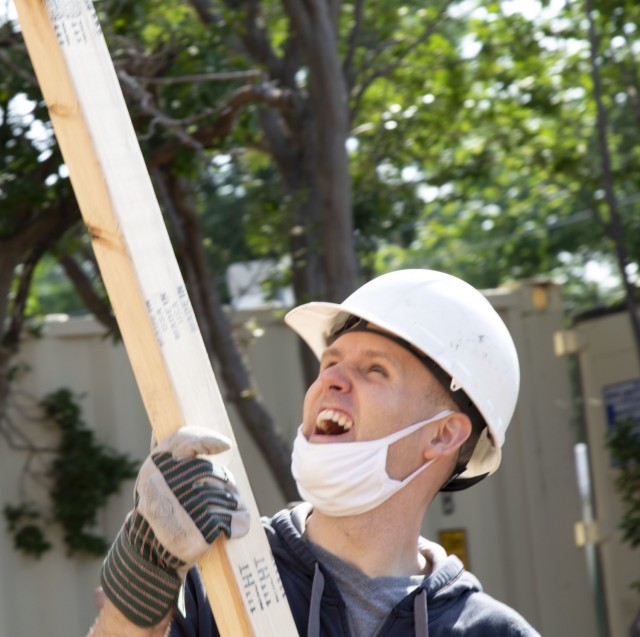 U.S. Army Reserve Staff Sgt. William Hammons, an operations noncommissioned officer assigned to the Mobilization Demobilization Operations Center (MDOC) from the 2-381st Training Support Battalion, 120th Infantry Brigade, Division West, assists with lifting a wooden roof frame during a Habitat for Humanity housing project in Waco, Texas, May 16, 2021. Hammons, along with other Army Reserve Soldiers on the MDOC team used this volunteer opportunity to frame a creative way for team and leadership building while also supporting the local community. (U.S. Army Photo by Staff Sgt. Erick Yates)