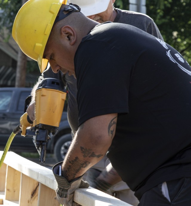 U.S. Army Reserve Staff Sgt. Jose Gonzalez, a resources and support lead assigned to the Mobilization Demobilization Operations Center (MDOC) from the 2-381st Training Support Battalion, 120th Infantry Brigade, Division West, assists a volunteer with fastening a wood frame during a Habitat for Humanity housing project in Waco, Texas, May 16, 2021.  Gonzalez, along with other Army Reserve Soldiers on the MDOC team used this volunteer opportunity to frame a creative way for team and leadership building while also supporting the local community. (U.S. Army Photo by Staff Sgt. Erick Yates)