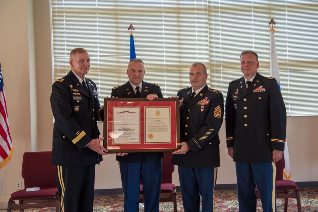 Brigadier Gen. Ralph Hedenberg (left), director of the Connecticut National Guard joint staff, presents the Army Superior Unit Award to Col. L.J. Fusaro and Command Sgt. Maj. Paul Vicinus, commander and senior enlisted advisor, respectively, for the 169th Regiment (Regional Training Institute) during a ceremony at Camp Nett in Niantic, Conn. May 22, 2021. The regiment earned the award between April 1, 2016 and March 31, 2017 by achieving the highest rating possible and no negative remarks on any of the 28 specific accreditation-based functional areas of its triennial accreditation, developing and hosting a Training Institute Pre-Command Course to meet the needs of the state’s senior leadership, and provided strategic influence on the national rebalance of RTIs within the Military Police career management field.