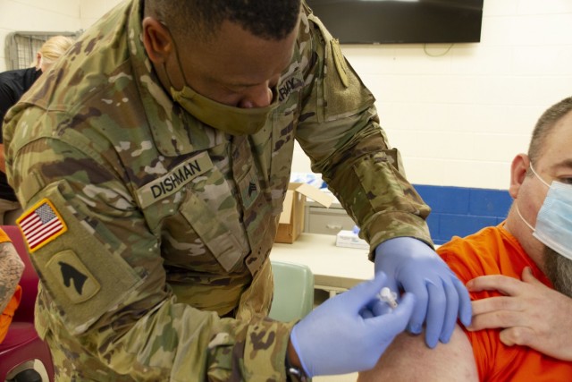 Sgt. Okoarye Dishman, a medic assigned to vaccination strike team two, Kentucky National Guard, admi