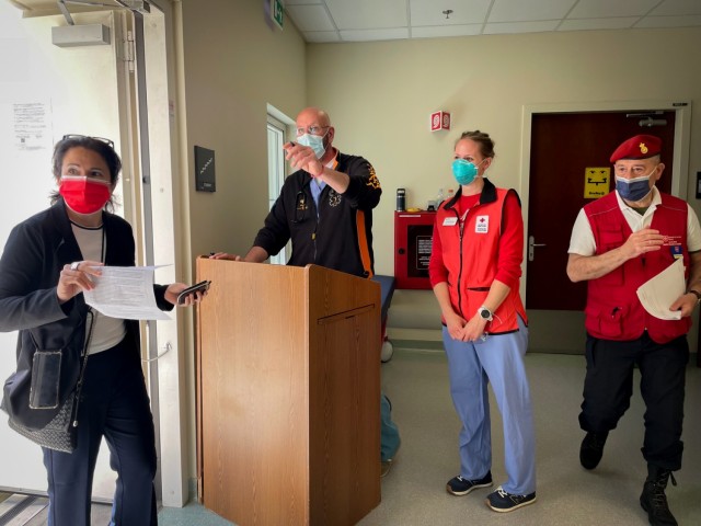 Volunteers from the Vicenza chapter of the Italian Relief Corps of the Order of Malta, American Red Cross, and staff members of the USAHC-Vicenza check-in and direct a host nation professional to receive the first dose of the Pfizer vaccine May 25, 2021.