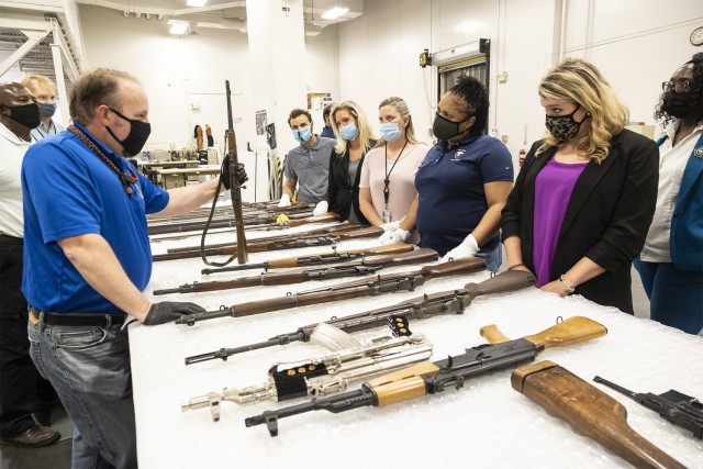 Team members from the Army Materiel Command’s Public Affairs and Protocol offices watch as an employee from the Museum Support Center displays weapons from the Civil War, World II and other time periods.