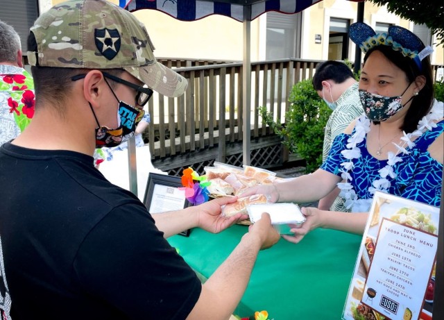 Christine Swanson shares Asian food that she prepared with Sgt. David Cavazos, a noncommissioned officer with 54th Brigade Engineer Battalion, during a troop lunch, May 27, at Caserma Ederle, Vicenza, Italy.