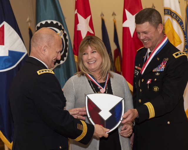 Gen. Ed Daly presents a stained glass AMC logo to Maj. Gen. Daniel Mitchell and his wife, Lori, during a relinquishment of command and retirement ceremony May 27. (Photo by Linda Lambiotte, ASC Public Affairs)