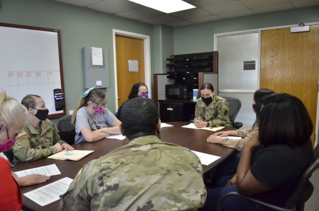 Staff Sergeant Jeannine Valencia, noncommissioned officer in charge, Patient Administration Division, Blanchfield Army Community Hospital, center, meets with a group of Soldiers and civilian employees May 21. Valencia was recently inducted into the Sgt. Audie Murphy Club for her leadership skills and commitment to Soldiers and Families.