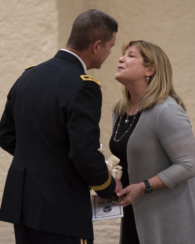 Maj. Gen. Daniel Mitchell kisses his wife, Lori, after presenting her with flowers during his retirement ceremony May 27 Mitchell also relinquished command of the U.S. Army Sustainment Command during the ceremony. (Photo by Linda Lambiotte, ASC...