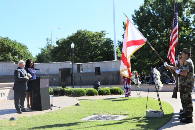 Members of the Young Marine Corps present the colors during the National Anthem sung by Army Materiel Command employee Sheena Collier at the Huntsville Memorial Day Ceremony at the Huntsville/Madison County Veterans Memorial, May 31, 2021. Standing with Collier is Medal of Honor recipient and retired Capt. Mike Rose, who commanded the presentation.