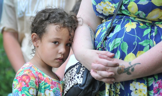 Five-year-old Natalia Booker stays close to her mother, Loretta Booker, during the invocation of the Butterfly Release event May 26 at the Army Community Service Memorial Garden. The Bookers were present to honor and remember father and husband,...