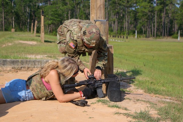 1st Lt. Amanda Atkinson from 9th Brigade Engineer Battalion, 2nd Armor Brigade Combat Team, 3rd Infantry Division, instructs a spouse how to clear a weapons malfunction on an M4 Carbine on May 27, 2021, at Small Arms Range Charlie, Fort Stewart,...