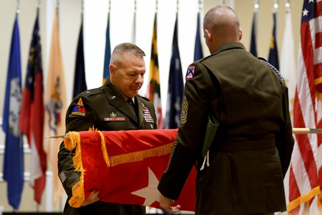 Brig. Gen. Charles Lombardo, Combined Arms Center-Training Deputy Commanding General and Mission Command Training Program Command Sgt. Maj. Joseph Wilson unfurl Lombardo’s one-star flag during his promotion ceremony May 28, 2021 at the Frontier Conference Center, Fort Leavenworth, Kan. Photo by Tisha Swart-Entwistle, Combined Arms Center-Training.