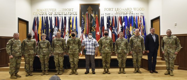 Maj. Gen. James Bonner, Maneuver Support Center of Excellence and Fort Leonard Wood commanding general (left), and MSCoE and Fort Leonard Wood Command Sgt. Maj. Randolph Delapena (right) pose for a photo with MSCoE's calendar year 2020...