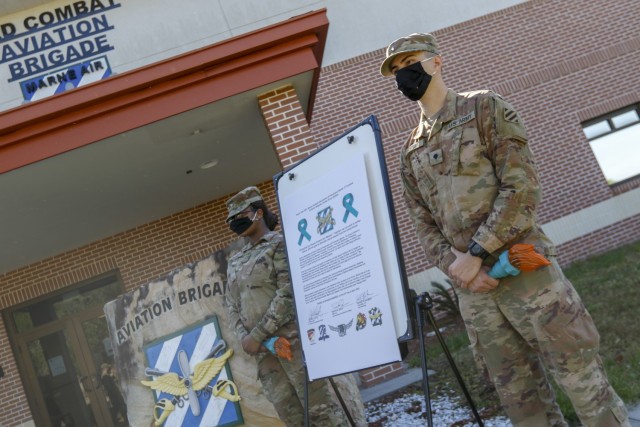 Representatives of the Marne Air Advisory Board, Pvt. Kelle Ross (left) and Spc. Cameron Forte (right), assigned to the the 3rd Combat Aviation Brigade, 3rd infantry Division, stand next to the sexual assault awareness and prevention proclamation,...