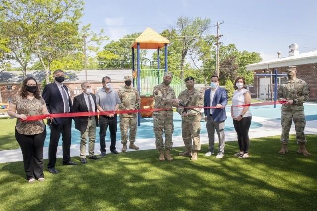 U.S. Army photo by Todd Moses – Brig. Gen. Vincent Malone, Picatinny Arsenal Commanding General, (center left with scissors) and Lt. Col Adam Woytowich, Picatinny Arsenal Garrison Commander, cut the red ribbon to signify  the opening of Picatinny Arsenal’s new Child Development Center playground, during a ceremony on May 20.