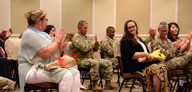Tracy Rainey, spouse of outgoing Combined Arms Center and Fort Leavenworth Commanding General Lt. Gen. James Rainey, and audience members applaud Stephanie Martin, spouse of incoming CAC and Fort Leavenworth Commanding General Lt. Gen. Theodore...