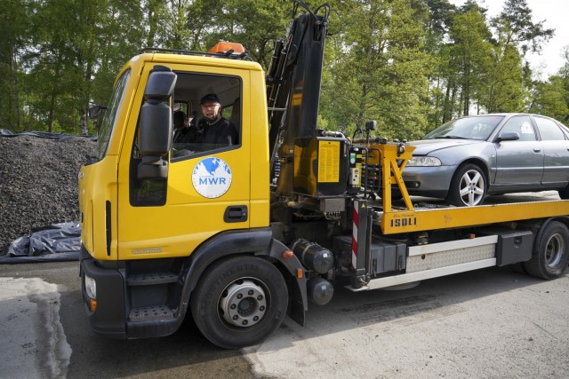 An FMWR tow truck tows abandoned vehicles to a location to be salvaged and sold as an initiative to remove abandoned vehicles from the installation.